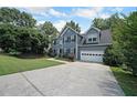 Beautiful two-story house showcasing a wide driveway, two-car garage and a green yard at 5176 Shotwell St, Woodstock, GA 30188