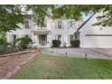 Charming two-story home with a white brick facade, accented by gray shutters and mature trees at 7045 Hunters Ne Knl, Sandy Springs, GA 30328
