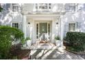 Inviting front porch features a neutral door, decorative plants, and stylish lighting fixtures at 7045 Hunters Ne Knl, Sandy Springs, GA 30328