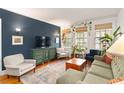 Living room with hardwood floors, a blue accent wall, and bright windows that bring nature indoors at 1166 Virginia Avenue Ne Ave # 8, Atlanta, GA 30306