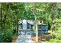 Home's inviting front exterior with two-car garage, lush trees, and well-manicured yard offers great curb appeal at 3402 Devoe Ct, Marietta, GA 30062