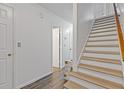 Hallway with stairs, wood-look flooring, and neutral paint. A simple, yet classic, design at 4691 Shumate Dr, Stone Mountain, GA 30083