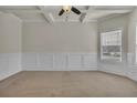 Bright living room featuring decorative ceiling, large window, neutral carpet, and wainscoting at 1354 Slate Bend Dr, Dacula, GA 30019