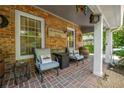 Relaxing outdoor seating on a brick porch with a view, featuring stylish chairs, decorative barrels, and cozy accents at 4442 Academy St, Acworth, GA 30101