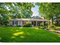 Inviting single-story house showcasing a large green lawn, well-maintained landscaping, and traditional architectural details at 4442 Academy St, Acworth, GA 30101