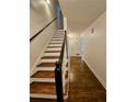 Interior view of the staircase with hardwood steps and a black handrail, leading to the upper level at 713 Trickum Valley Dr, Woodstock, GA 30188