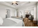 Spacious main bedroom featuring hardwood floors and a sitting area with two chairs, with a view to the main bathroom at 942 Elwood St, Dacula, GA 30019