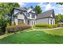 Beautifully landscaped front yard of a two-story home, featuring lush greenery and manicured bushes at 135 Emerald Ln, Roswell, GA 30075