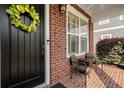 Inviting front porch with brick siding, a decorative wreath on the door, and cozy chairs for relaxing outdoors at 6430 Banbury Se Ct, Mableton, GA 30126
