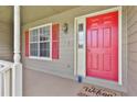 Welcoming entrance with a vibrant red door, stylish window, and charming 'Welcome' mat at 100 Walnut Ct, Stockbridge, GA 30281