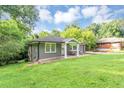 Single story home with a lush front lawn, mature landscaping, and an inviting front porch with chairs at 2123 Garden Cir, Decatur, GA 30032