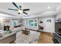 Bright living room with a large window, hardwood floors, tray ceilings, and a modern ceiling fan at 2123 Garden Cir, Decatur, GA 30032