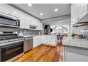 Modern kitchen with stainless steel appliances, white cabinets and hardwood floors at 22107 Harvest Ridge Lane # 22, Alpharetta, GA 30022