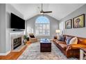 Bright living room featuring vaulted ceilings, a fireplace, and a large arched window at 22107 Harvest Ridge Lane # 22, Alpharetta, GA 30022