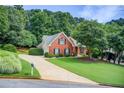 Attractive home features a brick facade, lush landscaping, and a long driveway at 3030 Larkspur Ct, Cumming, GA 30041