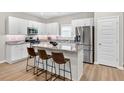Eat-in kitchen boasts stainless steel appliances, granite countertops, white cabinets, and a breakfast bar at 165 Winner St, Acworth, GA 30102