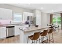 Eat-in kitchen boasts stainless steel appliances, granite countertops, white cabinets, and a breakfast bar at 165 Winner St, Acworth, GA 30102
