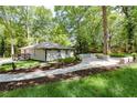 This outdoor space features a stone patio area surrounded by beautiful green grass and mature trees at 3200 Lowndes St, East Point, GA 30344