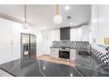 Modern kitchen features white cabinets, stainless steel appliances, a gas range, and striking black countertops at 3200 Lowndes St, East Point, GA 30344