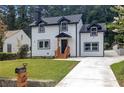 Beautifully renovated two-story home with a fresh, well-kept lawn and a paved driveway leading to the property at 656 S Elizabeth Nw Pl, Atlanta, GA 30318