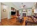 Cozy living room with a fireplace, hardwood floors, vaulted ceiling, and large windows offering plenty of natural light at 672 Victorian Cir, Dallas, GA 30157