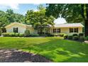 Charming single-story home with a lush green lawn, mature trees, and manicured landscaping at 230 Thistlewood Ln, Roswell, GA 30075
