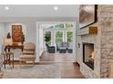 Cozy living room with a stone fireplace and a view into a sunroom at 230 Thistlewood Ln, Roswell, GA 30075
