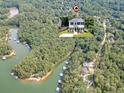 Beautiful aerial view of home near lake access surrounded by lush green trees and boathouses at 5350 Mercedes Dr, Cumming, GA 30041