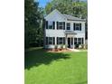 Beautifully landscaped lawn and two-story home featuring black shutters and a classic, inviting design at 5350 Mercedes Dr, Cumming, GA 30041
