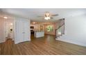 Bright and airy living room flows into the kitchen area with modern stairs and wood flooring at 5350 Mercedes Dr, Cumming, GA 30041