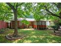 Serene backyard with shade trees, partial fencing, and a cozy sunroom attached to the brick home, offering a peaceful retreat at 2581 N Clark Dr, Atlanta, GA 30344