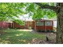 Private backyard featuring a partial fence, cozy sunroom, and lush greenery with mature trees creating a serene outdoor space at 2581 N Clark Dr, Atlanta, GA 30344