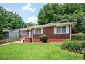 Classic brick house with manicured lawn and white-trimmed windows, showcasing its traditional charm in a peaceful neighborhood at 2581 N Clark Dr, Atlanta, GA 30344