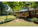 Beautiful backyard with a wooden deck, lush lawn, trees, and a swing set, perfect for outdoor enjoyment at 4138 Hickory Dr, Powder Springs, GA 30127