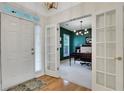 Bright foyer with hardwood floors, glass door access to an office space with view of chandelier at 4140 Prince Charles Dr, Duluth, GA 30097