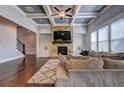Spacious living room with a stone fireplace, coffered ceiling, and hardwood floors at 5540 Wood Falls Dr, Buford, GA 30518