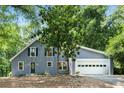 Charming blue home with attached garage and mature trees in the front yard at 3617 Lassiter Rd, Marietta, GA 30062