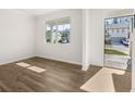 Sunlit living room with hardwood floors and a large window offering scenic views of the neighborhood at 915 Sundown Pt, Villa Rica, GA 30180