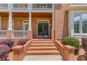 Elegant brick entrance with double doors and manicured landscaping at 2748 Hidden Falls Dr, Buford, GA 30519