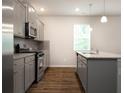 Modern kitchen featuring gray cabinets, stainless steel appliances, and granite countertops at 904 Sundown Pt, Villa Rica, GA 30180