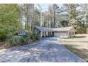 Lovely ranch-style home with an attached two-car garage, surrounded by beautiful trees and a long private drive at 1373 W Prospect Dr, Lawrenceville, GA 30043