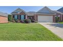 Charming brick home with a well-manicured lawn and two-car garage under a clear blue sky at 1550 Rolling View Dr, Cumming, GA 30040
