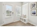 Bright entryway with convenient built-in bench, coat hooks, and decorative wall art at 2022 Wyndham Pl, Conyers, GA 30013