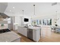 Open-concept kitchen featuring a marble island, stainless steel appliances, and a seamless flow into the living area at 6820 Colfax Ave, Cumming, GA 30040