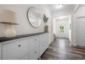 Inviting entryway with a modern storage unit, mirror, hardwood floors, and bright lighting at 5318 Burrus Ln, Mableton, GA 30126