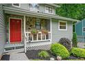 Charming front porch with stone accents, a bright red door, and decorative plants creating a welcoming entrance at 162 Nouveau Sw Ct, Lilburn, GA 30047