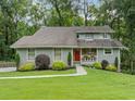 Inviting two-story home with well-maintained lawn, mature landscaping, and a striking red front door at 162 Nouveau Sw Ct, Lilburn, GA 30047
