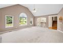 Spacious living room featuring vaulted ceiling, neutral carpet, and large windows that fill the space with light at 412 Gray Fox Dr, Canton, GA 30114