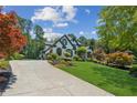 Beautiful home featuring a long driveway, lush landscaping, and manicured lawn at 6455 Darely Ct, Cumming, GA 30040