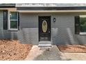 Close-up of the front door with decorative window, set in a gray brick facade at 5058 Rock Springs Rd, Lithonia, GA 30038